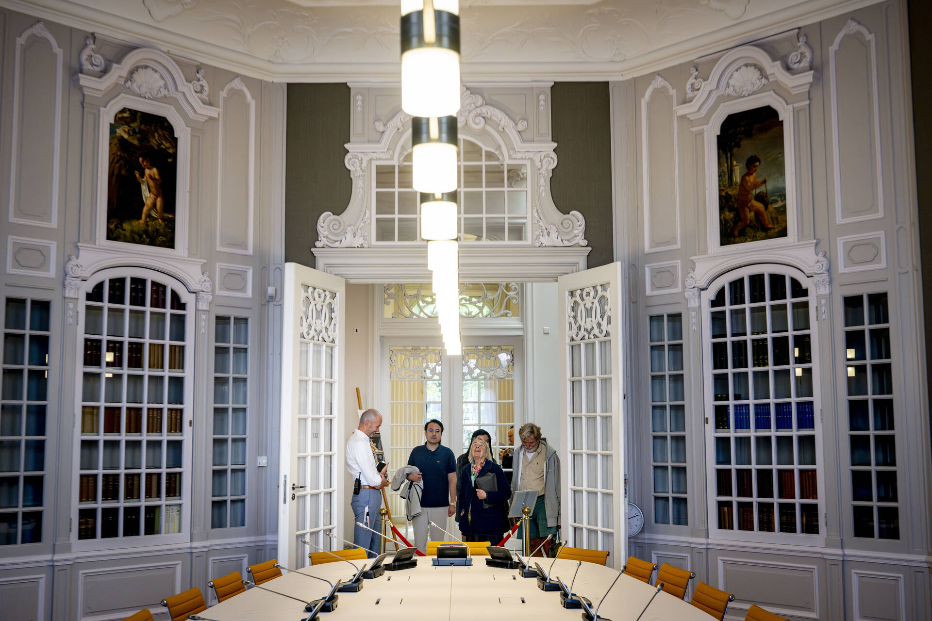 Bezoekers krijgen uitleg van medewerkers langs de route, hier over de Tuinzaal